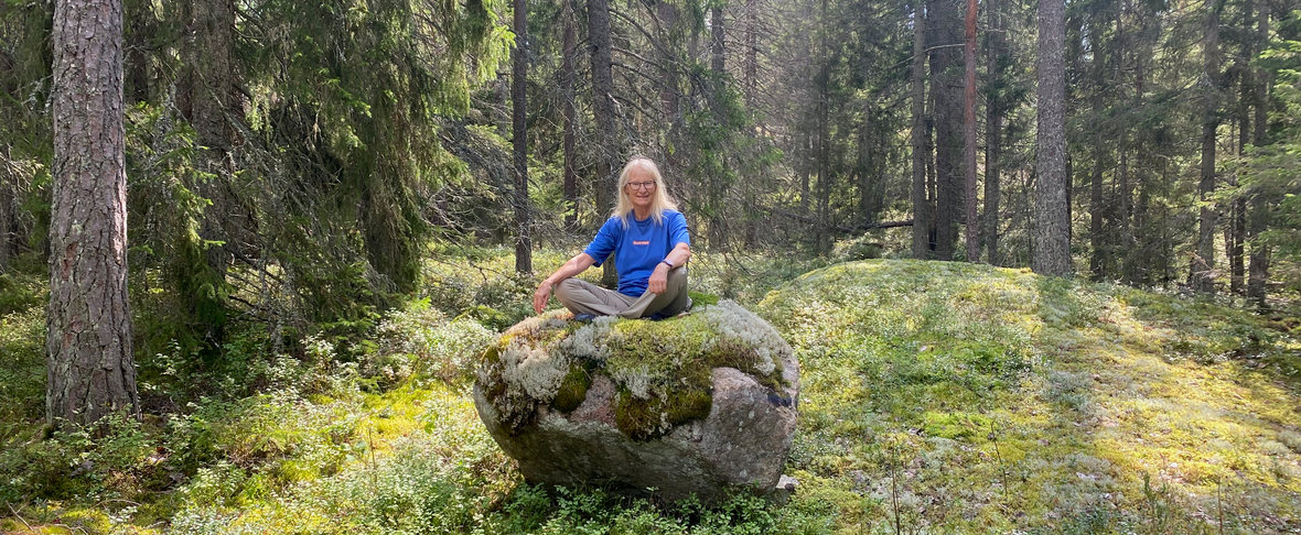May sitter på en sten i skogen